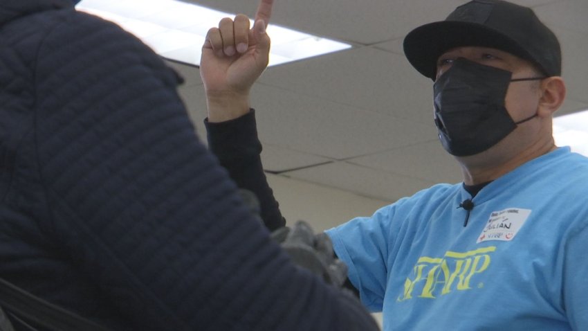 Man with a black mask and hat with a blue shirt