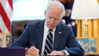 In this March 11, 2021, file photo, President Joe Biden signs the American Rescue Plan, a coronavirus relief package, in the Oval Office of the White House in Washington, D.C.