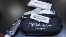 A pouch given to jurors containing face masks, gloves, disinfectant wipes, hand sanitizer and forehead thermometer strips is shown in a courtroom at a Manhattan federal courthouse, Friday, March 12, 2021, in New York.