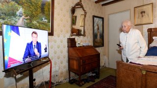 Renee Bodin, 94 years old, watches French President Emmanuel Macron's televised speech in her bedroom in Happonvilliers, near Chartres, eastern France, on March 31, 2021.
