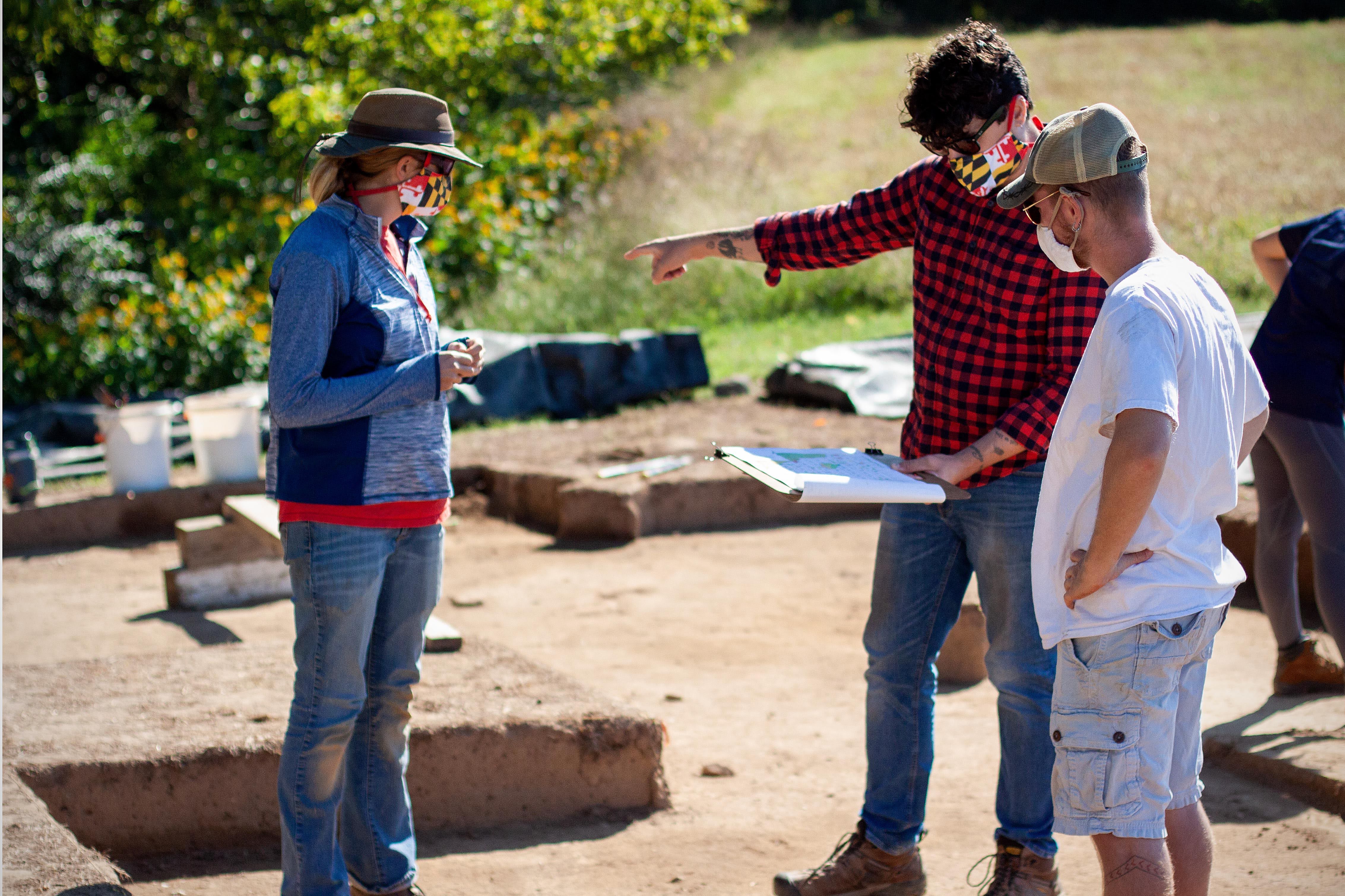 Historic St. Mary’s City archaeologists Stephanie Stevens and August Rowell consult with Director of Research and Collections Dr. Travis Parno (center) at the St. Mary’s Fort dig site.