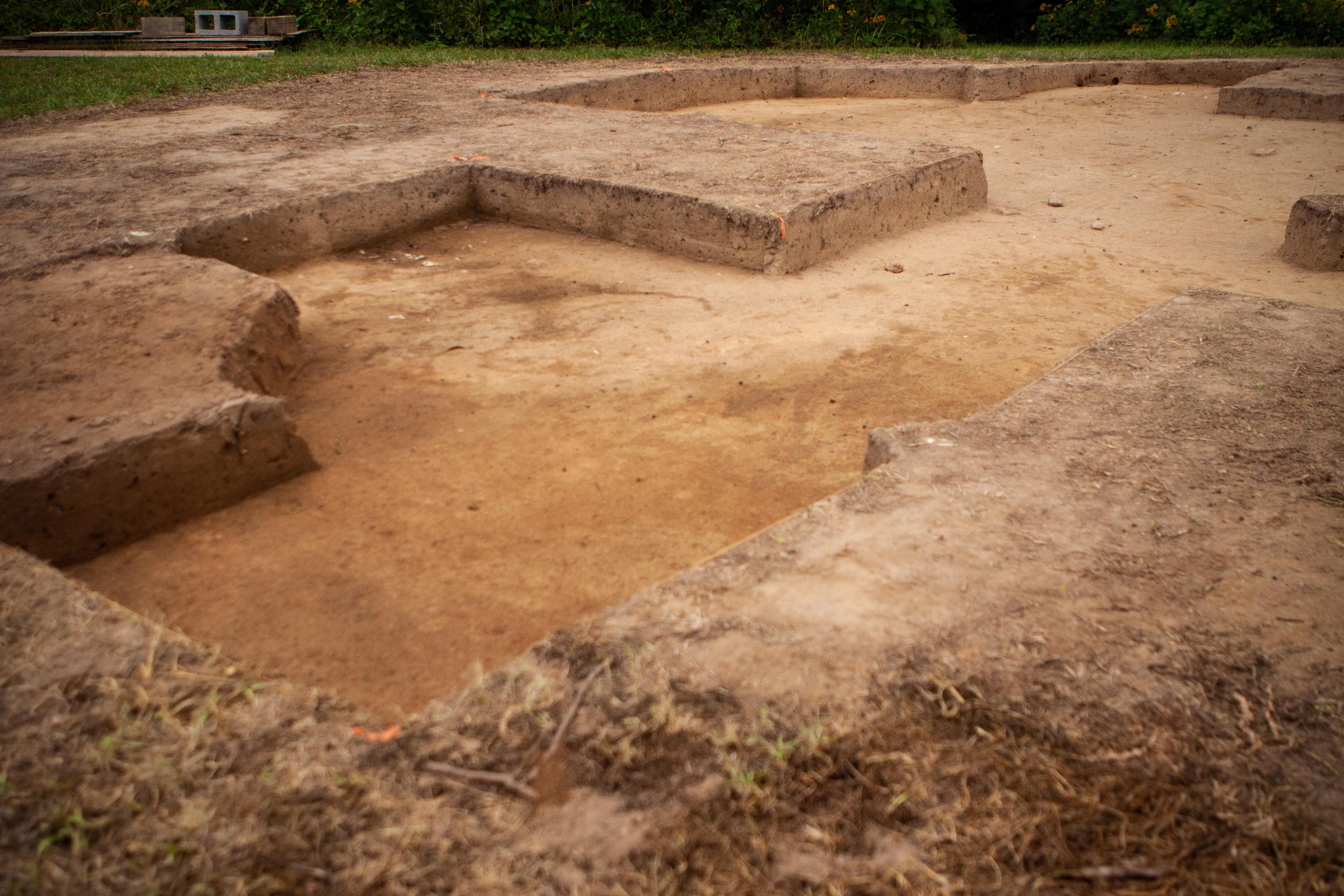 An excavated area near a fort-period building with a large cellar