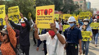 Anti-coup protesters display signs and shout slogans as they protest against the military coup in Mandalay, Myanmar, Monday, March 15, 2021. Myanmar's ruling junta has declared martial law in parts of the country's largest city as security forces killed more protesters in an increasingly lethal crackdown on resistance to last month's military coup.