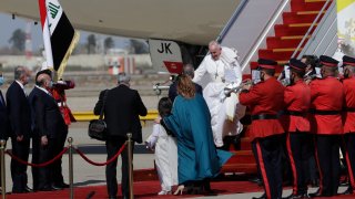Pope Francis walks down the steps of an airplane as he arrives at Baghdad international airport, Iraq, Friday, March 5, 2021. Pope Francis heads to Iraq to urge the country's dwindling number of Christians to stay put and help rebuild the country after years of war and persecution, brushing aside the coronavirus pandemic and security concerns.