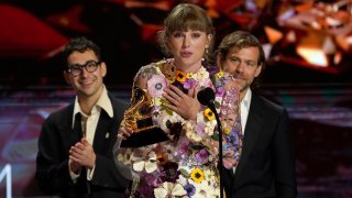 Taylor Swift accepts the award for album of the year for "Folklore"at the 63rd annual Grammy Awards at the Los Angeles Convention Center on Sunday, March 14, 2021. In background Jack Antonoff, left, and Aaron Dessner.
