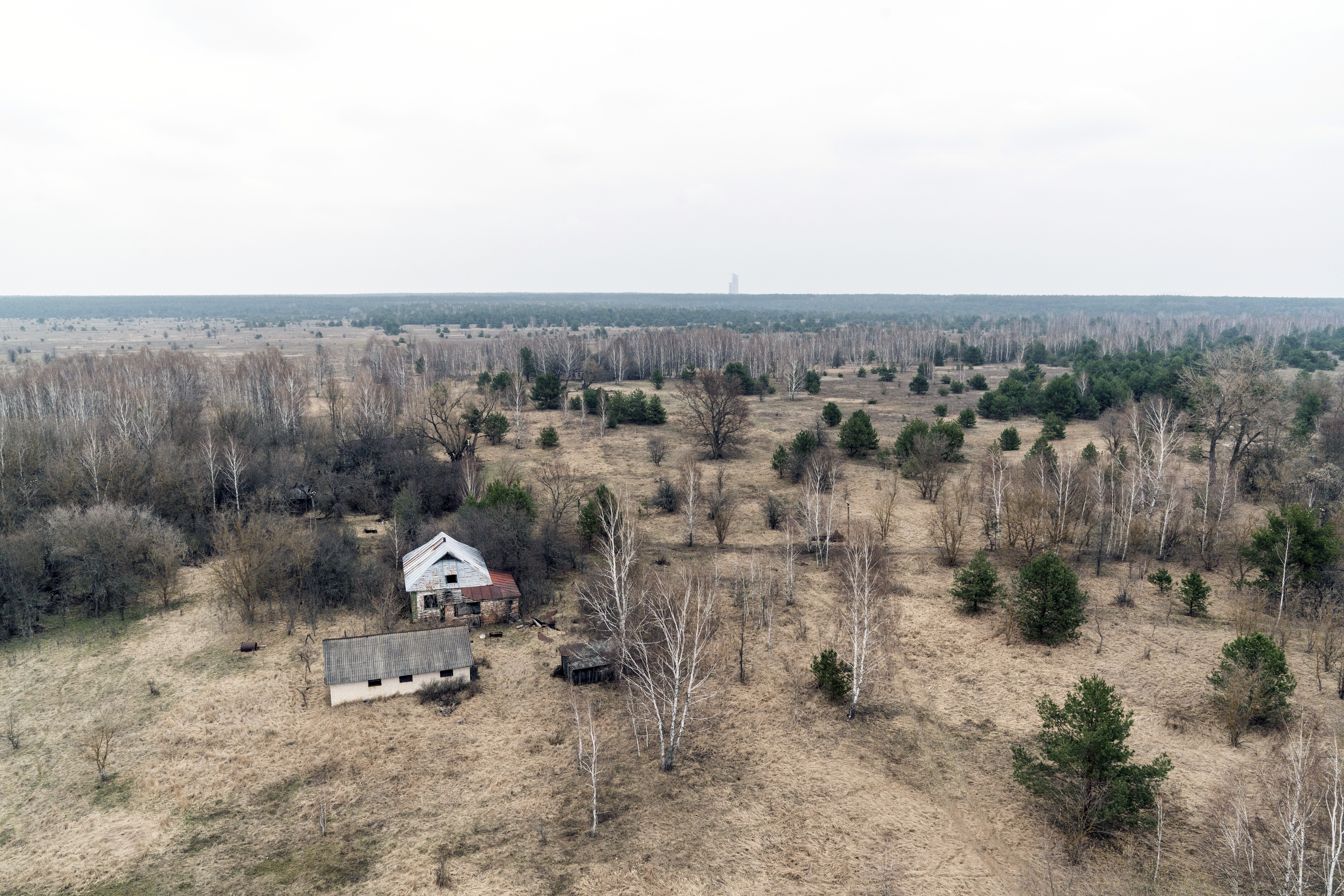 An abandoned village house and outbuildings are seen at the Chernobyl exclusion zone, Ukraine, April 13, 2021. The vast and empty Chernobyl Exclusion Zone around the site of the world’s worst nuclear accident is a baleful monument to human mistakes.