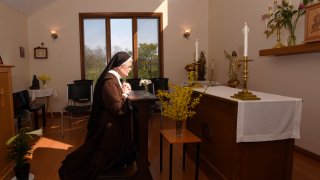 The Rev. Sister Barbara Smith, of the Order of Discalced Carmelites, prays on a prayer bench that belonged to The Rev. Mychal Judge, the Fire Department of New York's chaplain who died in the 2001 attacks on the World Trade Center, at the Episcopal Carmel of Saint Teresa in Rising Sun, Md., on Sunday, April 4, 2021. The Episcopal Carmel of Saint Teresa donated the prayer bench to the National Sept. 11 Memorial and Museum, representatives of which acquired the bench later in the morning.