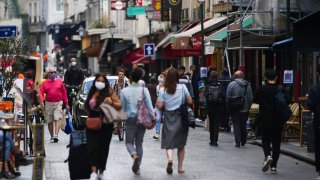 Pedestrians wear protective face masks while passing stores and cafes on Rue Montorgueil in Paris, France, on Wednesday, Aug. 26, 2020.Pedestrians wear protective face masks while passing stores and cafes on Rue Montorgueil in Paris, France