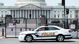 In this April 28, 2021, file photo, a U.S. Capitol Police patrol car drives past the fence perimeter on the east side of the U.S. Capitol before President Joe Biden delivers his address to the joint session of Congress.