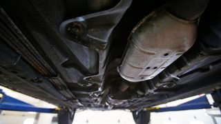 A catalytic converter sits under a Daewoo car on a lift at Valley Muffler and Brake in Menasha, Wis.