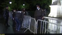 NYPD officers place barricades around Washington Square Park Sunday evening ahead of a new 10 p.m. weekend curfew.