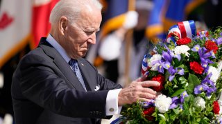 President Joe Biden adjusts a the wreath at the Tomb of the Unknown Soldier at Arlington National Cemetery on Memorial Day, Monday, May 31, 2021, in Arlington, Va.