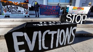 FILE - In this Jan. 13, 2021, file photo, demonstrators hold signs in front of the Edward W. Brooke Courthouse in Boston. A federal judge has ruled, Wednesday, May 5, 2021, that the Centers for Disease Control exceeded its authority when it imposed a federal eviction moratorium to provide protection for renters out of concern that having families lose their homes and move into shelters or share crowded conditions with relatives or friends during the pandemic would further spread the highly contagious virus.