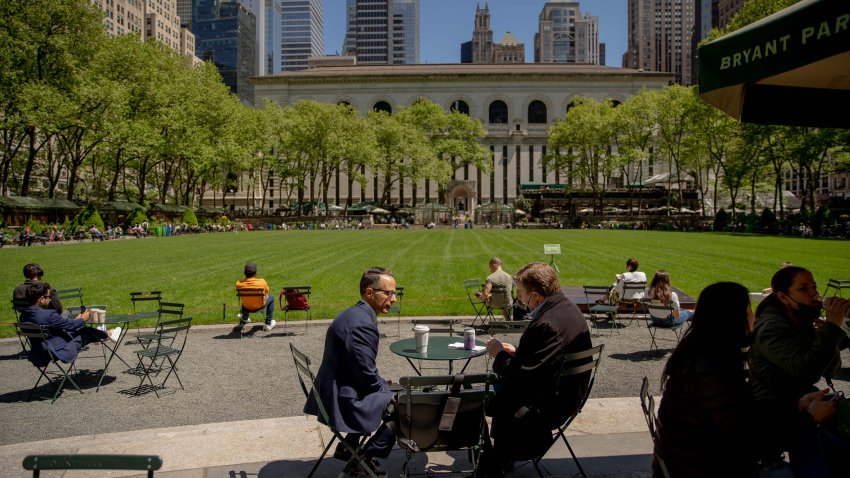 People sit outside in Bryant Park in New York, U.S., on Wednesday, May 12, 2021. With 37% of Manhattan fully vaccinated, the city's finance industry, slowly, is getting back into the office. Photographer: Amir Hamja/Bloomberg via Getty Images