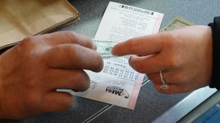 A customer purchases a Mega Millions lottery ticket at a 7-Eleven store