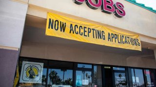 A sign reads “Now Accepting Applications” outside a Labor Systems office in Phoenix, Arizona, U.S., on Sunday, April 25, 2021.