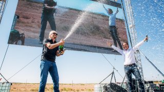Sir Richard Branson, left, and CEO Michael Colglazier celebrate the company’s third spaceflight test on May 22, 2021.
