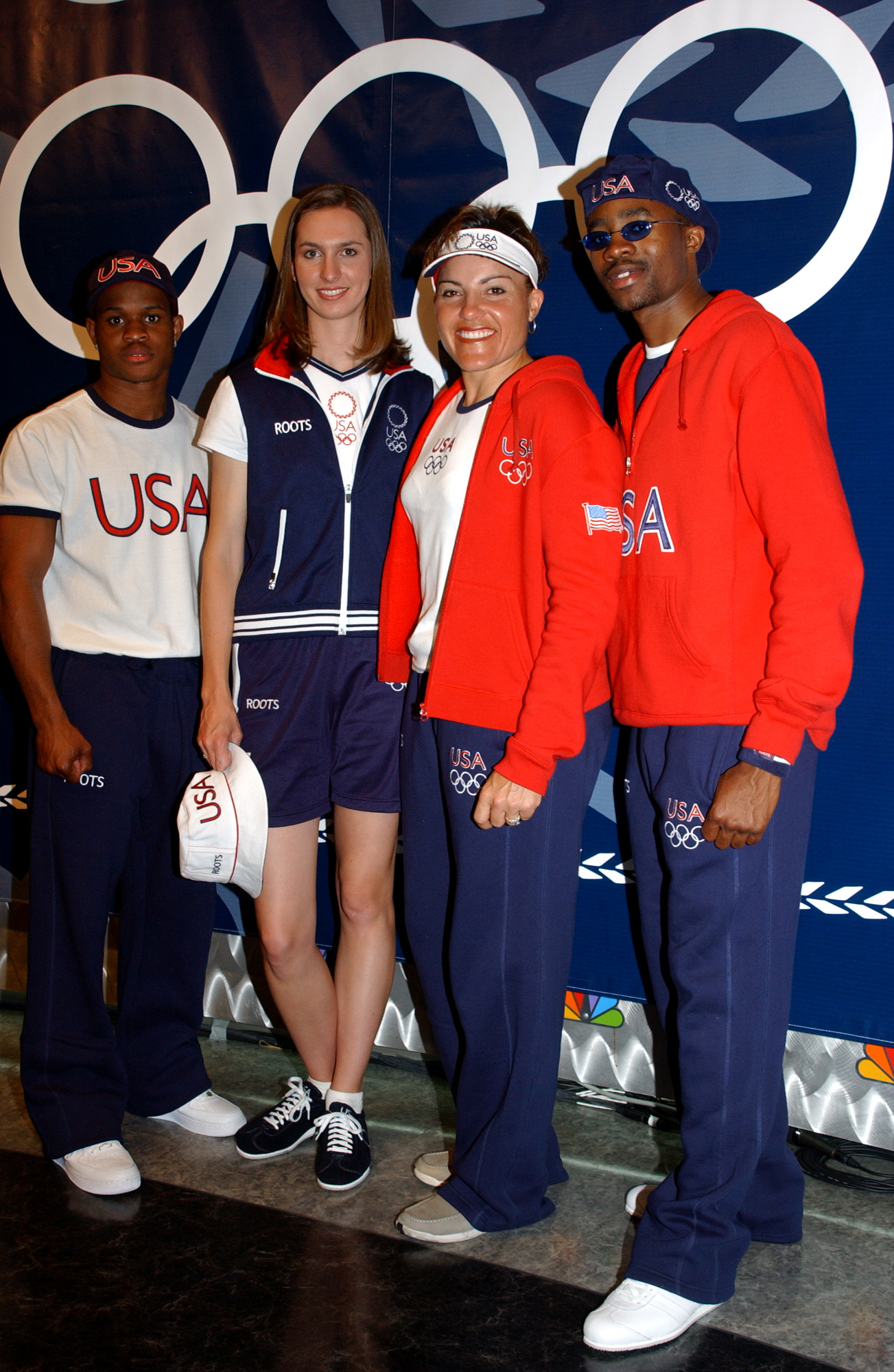 olympijští sportovci Spojených států, zleva boxer Rock Allen, softbalista Jennifer Nicholas, lukostřelec Lisa Fernandez a šermíř Ivan Lee modelují novou kolekci olympijského sportovního oblečení 2004 13. května 2004 v NBC Studios v New Yorku.