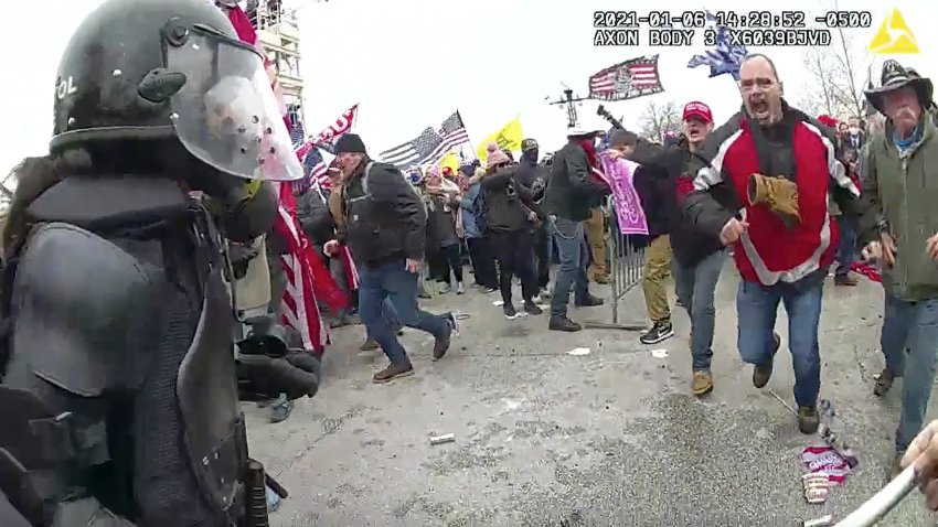 This still frame from Metropolitan Police Department body worn camera video shows Thomas Webster, in red jacket, at a barricade line at on the west front of the U.S. Capitol on Jan. 6, 2021, in Washington. Webster, a Marine Corps veteran and retired New York City Police Department Officer, is accused of assaulting an MPD officer with a flagpole. A number of law enforcement officers were assaulted while attempting to prevent rioters from entering the U.S. Capitol.