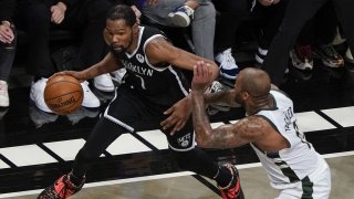 Brooklyn Nets' Kevin Durant, left, drives past Milwaukee Bucks' P.J. Tucker during the first half of Game 7 of a second-round NBA basketball playoff series