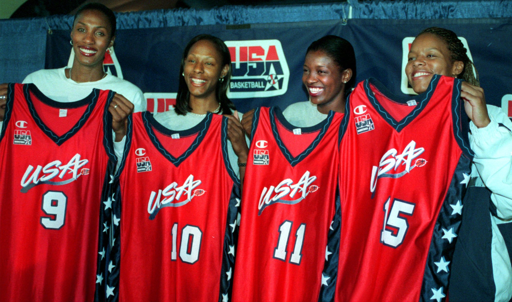 nové členky amerického ženského národního basketbalu zleva Lisa Leslie, Chamique Holdsclaw, DeLisha Milton a Nikki Mccrayová pózují se svými uniformami během tiskové konference v MCI Center během olympijských her 2000.