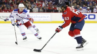 Washington Capitals left wing Shane Gersich (63) skates with the puck during his first NHL game in front of New York Rangers center Lias Andersson (50) during the first period at Capital One Arena.