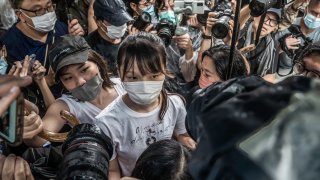 Agnes Chow (C) walks through the media pack after being released from the Tai Lam Correctional Institution.