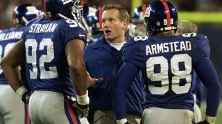 Giants head coach Jim Fassel huddles with Michael Strahan and Jesse Armstead in 2000