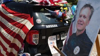 ARVADA, COLORADO - JUNE 22: Flowers, flags and notes cover a patrol car and bike outside Arvada City Hall during a memorial for Arvada Police Officer Gordon Beesley on June 22, 2021 in Arvada, Colorado. Officer Beesley was killed during a shooting in Olde Town Arvada.