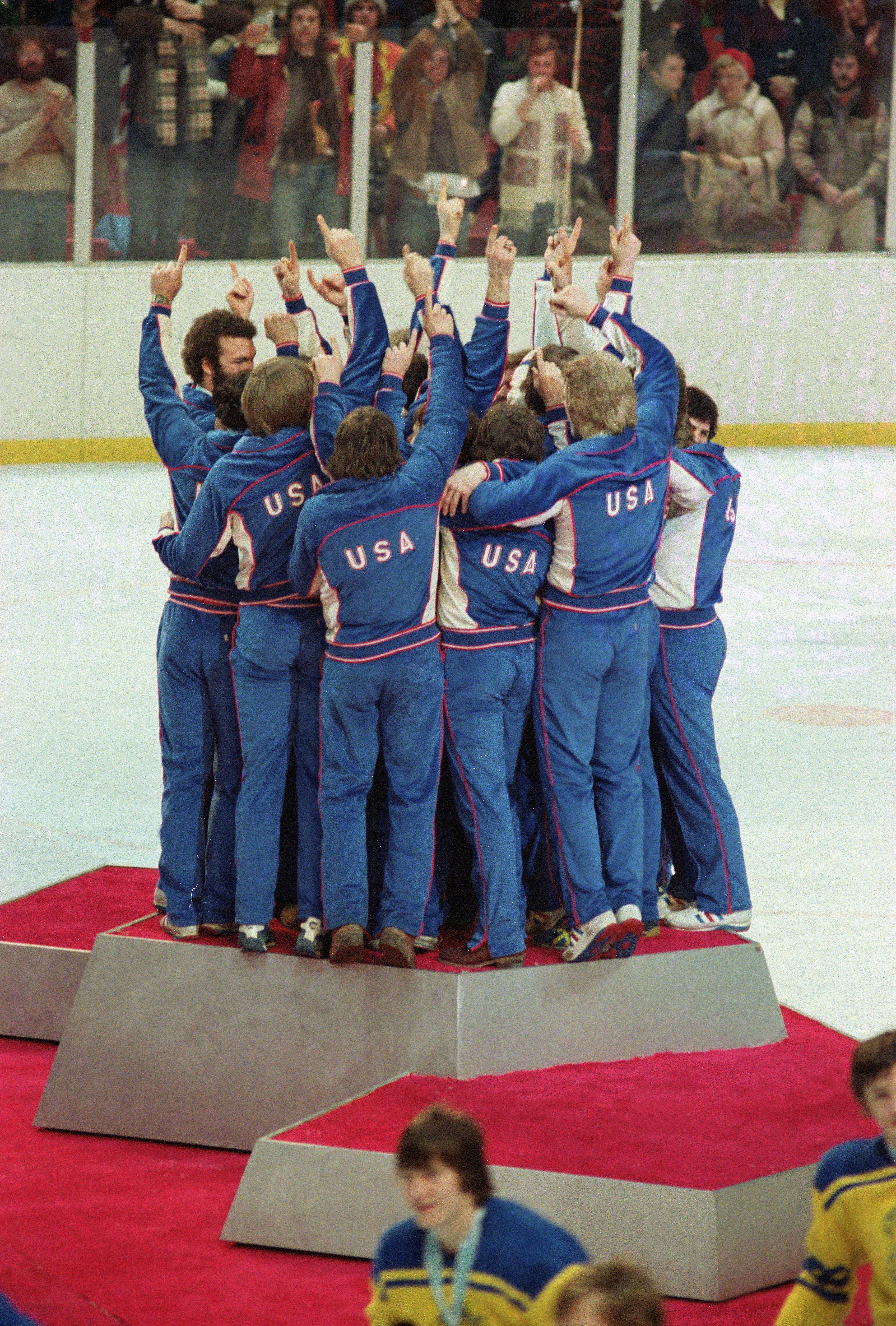 medlemmar av det amerikanska olympiska ishockeylaget för män firar på medaljpodiet efter att ha fått sina guldmedaljer i Lake Placid, New York, den Feb. 24, 1980.