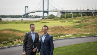 Eric Trump and Donald Trump Jr. pose for photos during a ribbon cutting event for a new clubhouse at Trump Golf Links at Ferry Point,