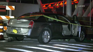 Police tape surrounds a dark sedan crashed in Coney Island following a carjacking, police said.