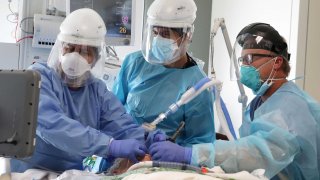 Dr. Dan Ponticiello, 43, and Dr. Gabriel Gomez, 40, intubate a coronavirus disease (COVID-19) patient in the COVID-19 ICU at Providence Mission Hospital in Mission Viejo, California, January 8, 2021.