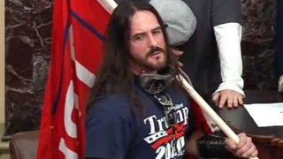 In this image from U.S. Capitol Police video, Paul Allard Hodgkins, 38, of Tampa, Fla., stands in the well on the floor of the U.S. Senate on Jan. 6, 2021, at the Capitol in Washington.