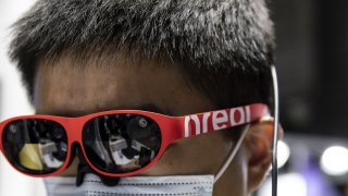 An attendee tries a pair of Nreal mixed-reality glasses at the MWC Shanghai exhibition in Shanghai, China, on Tuesday, Feb. 23, 2021.
