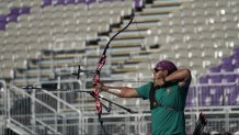 Backdropped by empty seat at Yumenoshima Park Archery Field Mexico's Luis Alvarez releases an arrow