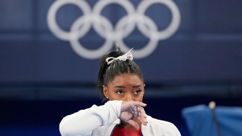 Simone Biles, of the United States, watches gymnasts perform at the 2020 Summer Olympics, Tuesday, July 27, 2021, in Tokyo. Biles says she wasn't in right 'headspace' to compete and withdrew from gymnastics team final to protect herself.
