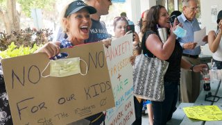 Joann Marcus of Fort Lauderdale, left, cheers as she listens to the Broward School Board's emergency meeting