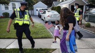 This photo from Monday July 13, 2020, shows Nassau County Police officers walk alongside protesters participating in a Black Lives Matter march through a residential neighborhood calling for racial justice in Valley Stream