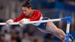 Suni Lee competes on the uneven bars