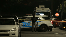 Police officers investigate the scene of a deadly shooting in Queens overnight.