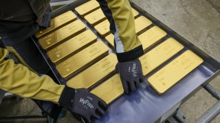 A worker loads 12,5 kilogram gold ingots onto a trolley ready for distribution in Krasnoyarsk, Russia.