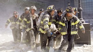 In this Sept. 11, 2021, file photo, FDNY firefighters carry fellow firefighter, Al Fuentes, who was injured in the collapse of the World Trade Center.