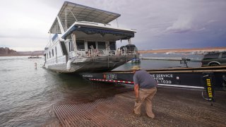 A family's houseboat is pulled from the Wahweap launch ramp after a three-week vacation at Lake Powell