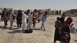 Stranded people gather and wait to open the border which was closed by authorities, in Chaman, Pakistan