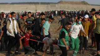 Medics evacuate a wounded person from the fence of Gaza Strip border with Israel