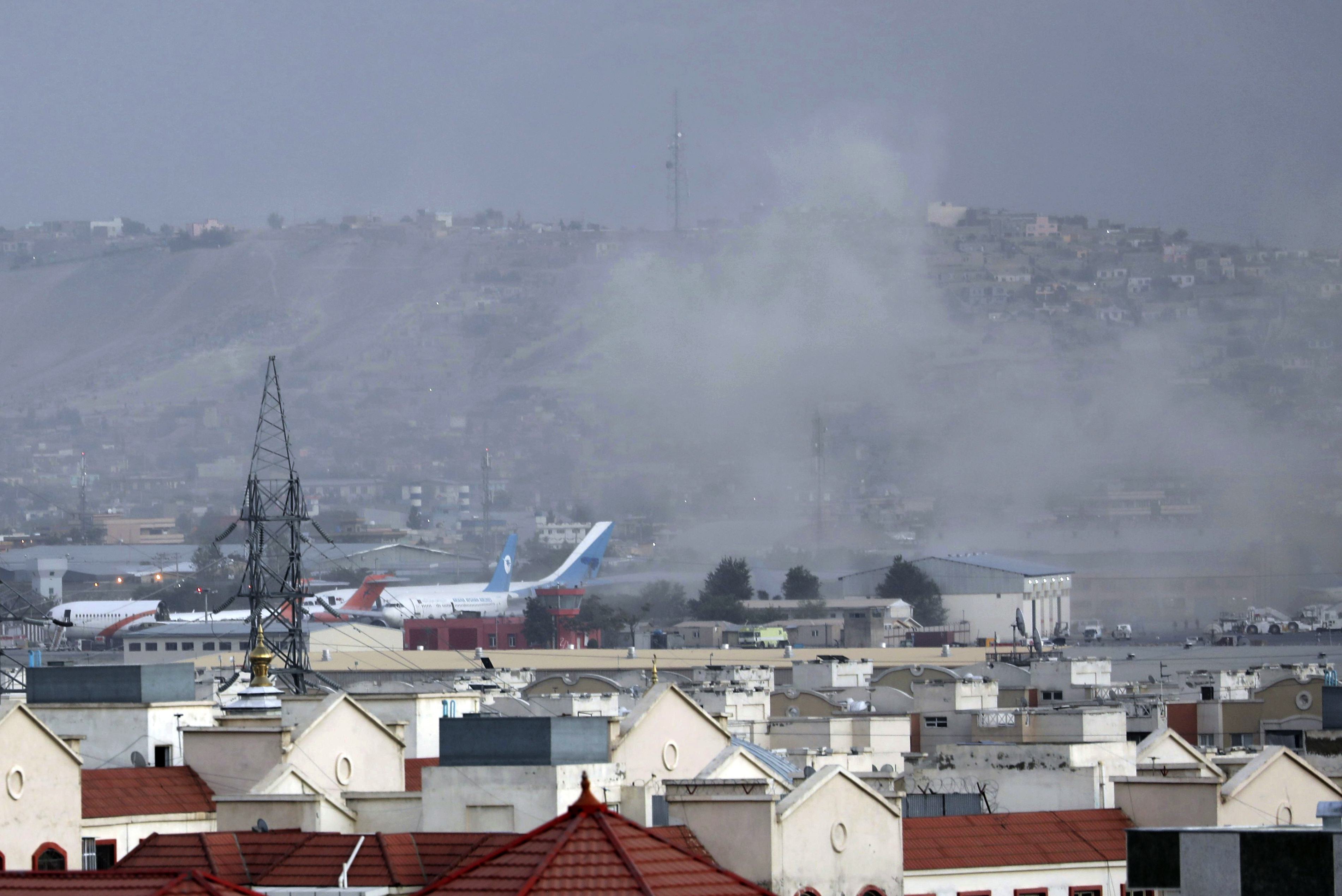 Smoke rises from a deadly explosion outside the airport in Kabul, Afghanistan, Thursday, Aug. 26, 2021. Two suicide bombers and gunmen have targeted crowds massing near the Kabul airport, in the waning days of a massive airlift that has drawn thousands of people seeking to flee the Taliban takeover of Afghanistan.