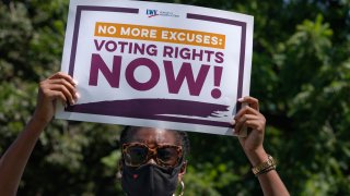 LaQuita Howard of Washington, with the League of Women Voters, attends a rally for voting rights, Tuesday, Aug. 24, 2021, near the White House in Washington.