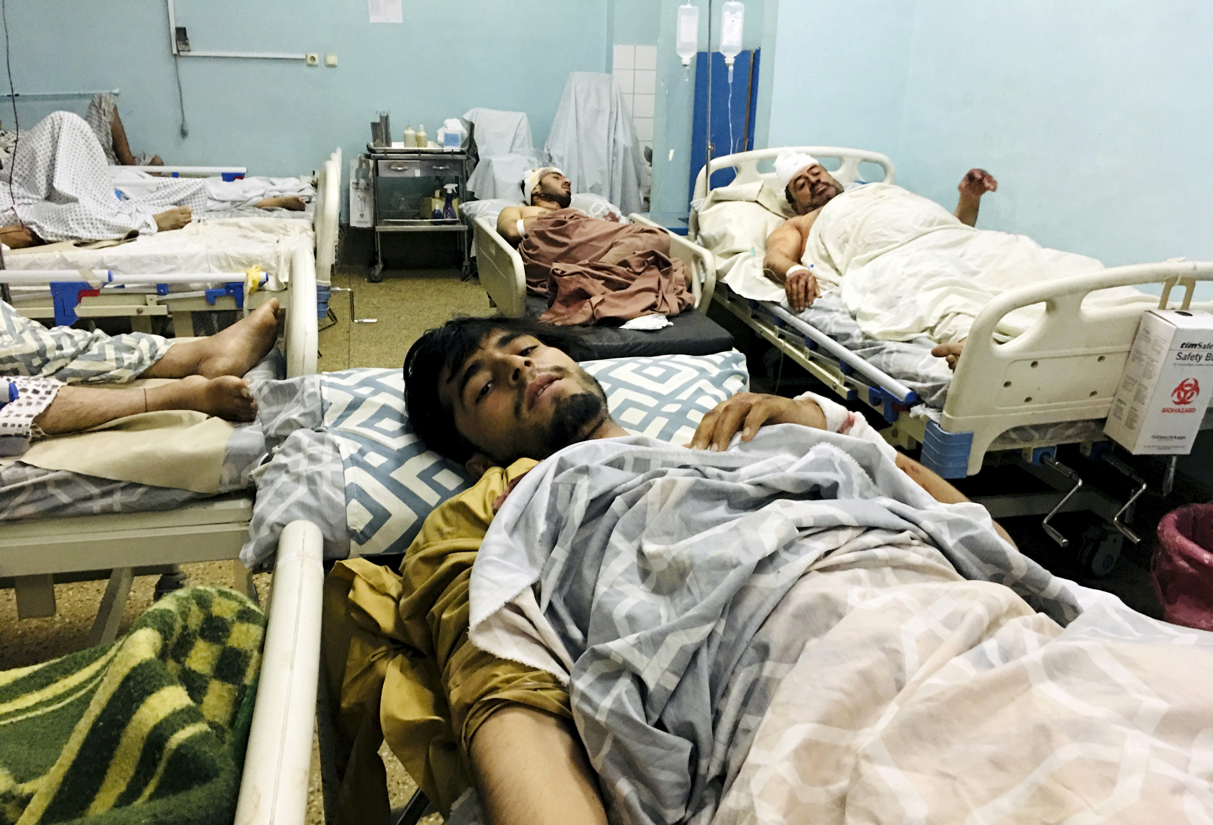 Wounded Afghans lie on a bed at a hospital after a deadly explosions outside the airport in Kabul, Afghanistan, Thursday, Aug. 26, 2021.