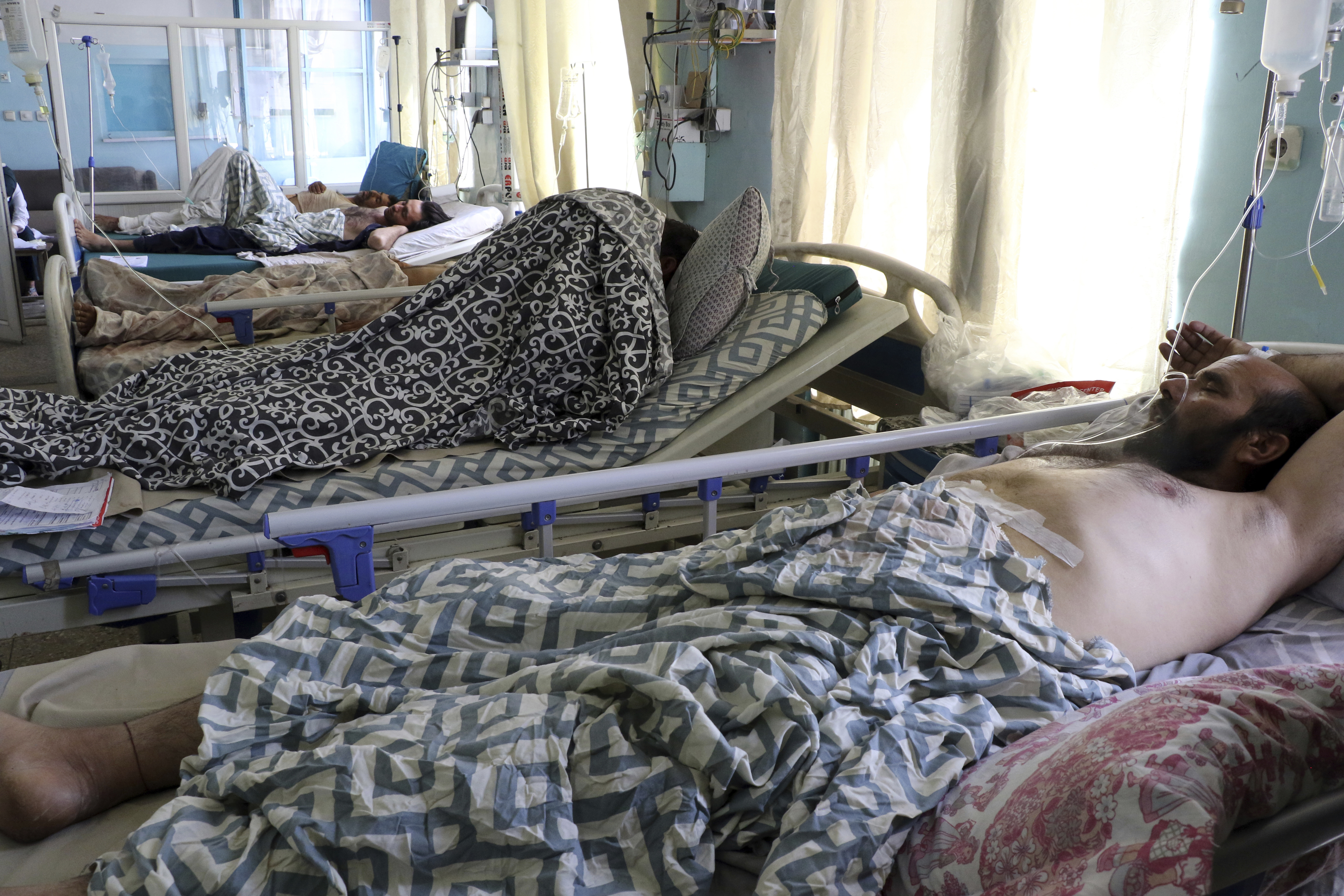 Afghans lie on beds at a hospital after they were wounded in the deadly attacks outside the airport in Kabul, Afghanistan, Friday, Aug. 27, 2021. Two suicide bombers and gunmen attacked crowds of Afghans flocking to Kabul’s airport Thursday, transforming a scene of desperation into one of horror in the waning days of an airlift for those fleeing the Taliban takeover.